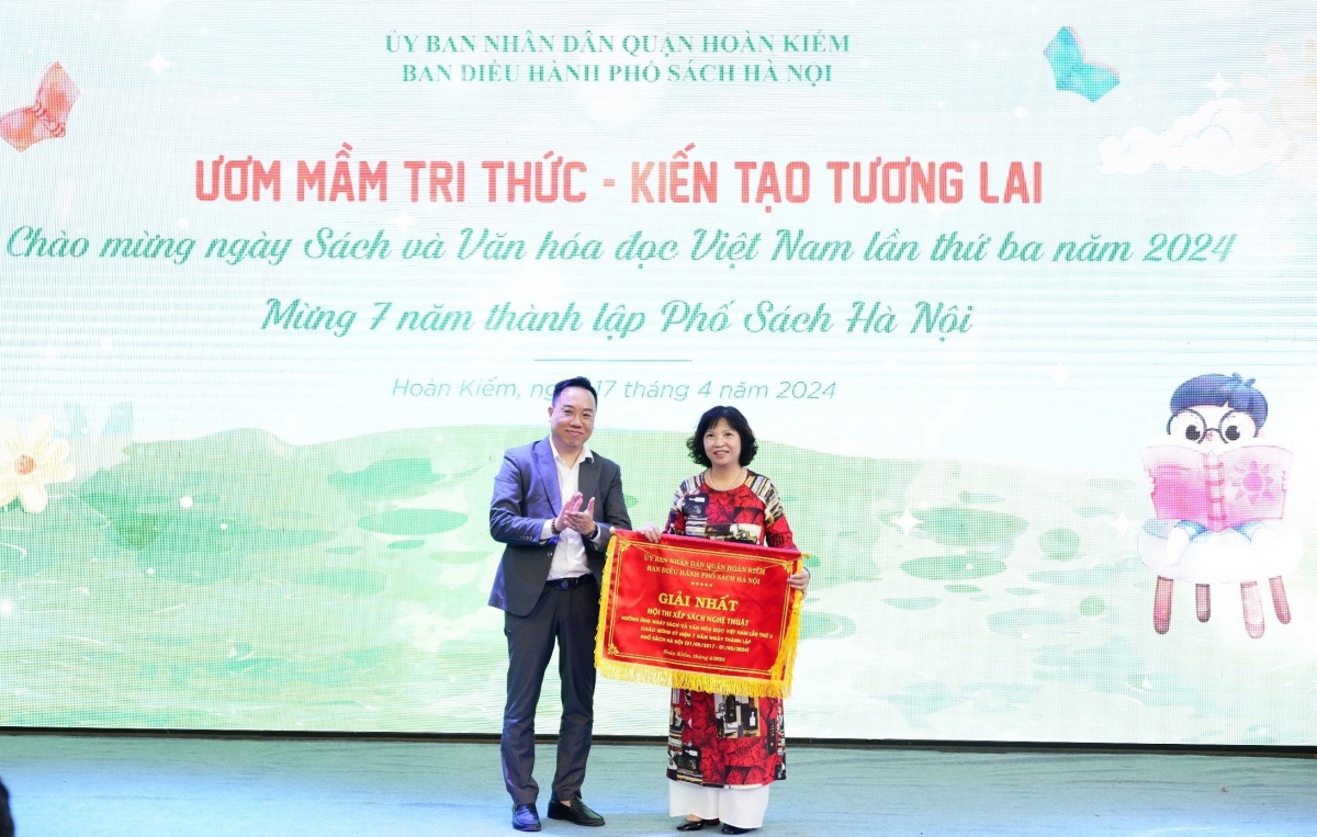 Ông Nguyễn Nguyên, Cục trưởng Cục Xuất bản, In và Phát hành (Bộ TTTT) trao Giải Nhất "Xếp sách nghệ thuật" cho đơn vị có gian hàng tại Phố Sách Hà Nội