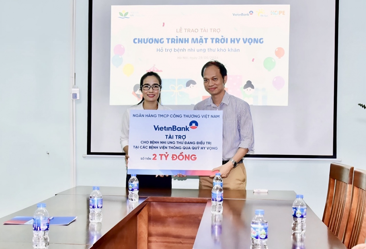 Bà Đoàn Thị Kiều Hương - Bí thư Đoàn Thanh niên VietinBank trao tài trợ 2 tỷ đồng cho ông Minh Nhân - đại diện chương trình Mặt trời Hy vọng