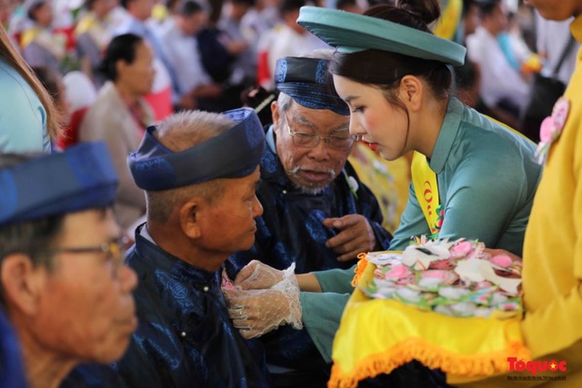 Cài hoa hồng hiếu hạnh tại lễ khai mạc.