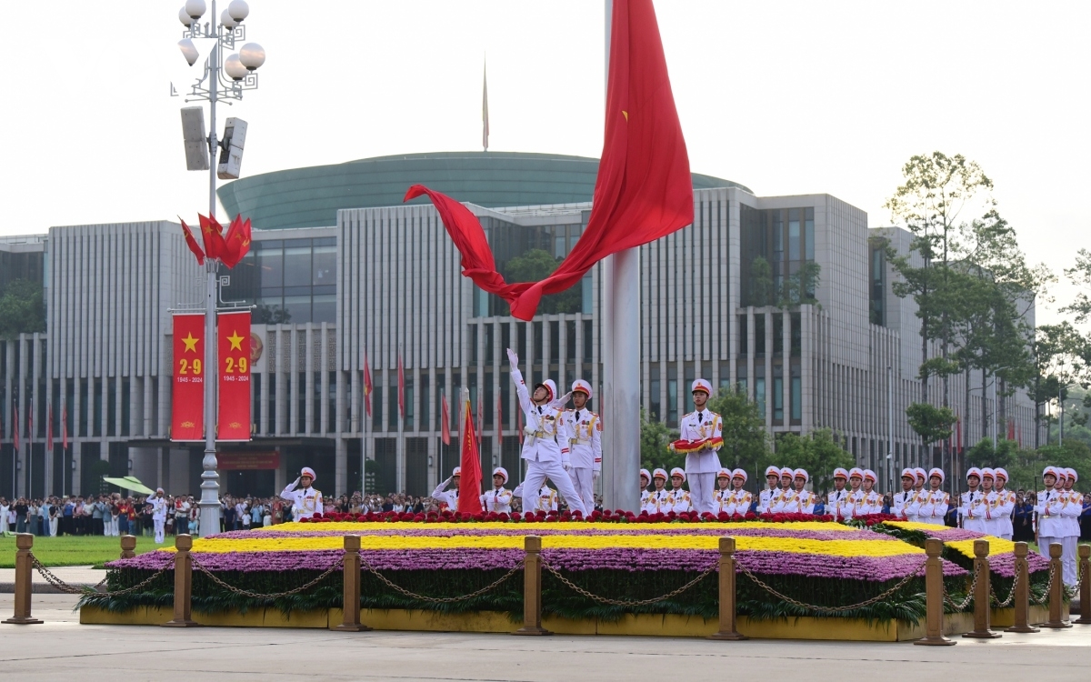 Chiến sĩ tung cờ và Quốc kỳ được kéo lên cột cờ cao 29 m trong không khí trang nghiêm.