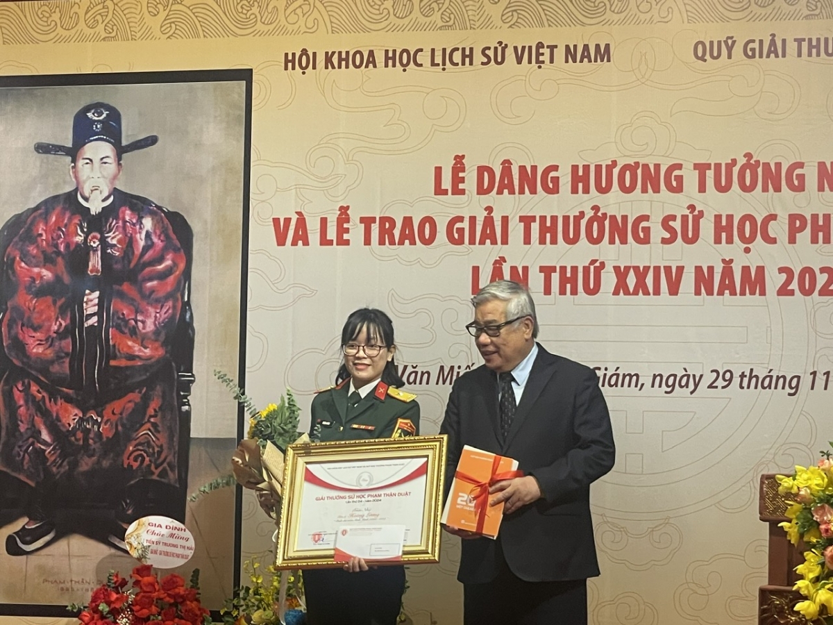 GS, TSKH, NGND Vũ Minh Giang, Phó chủ tịch Hội Khoa học Lịch sử Việt Nam, Chủ tịch Hội đồng xét Giải thưởng Phạm Thận Duật trao giải nhì cho Thiếu tá Hoàng Lương, Viện Lịch sử Quân sự VN. Ảnh:Tuyết Loan