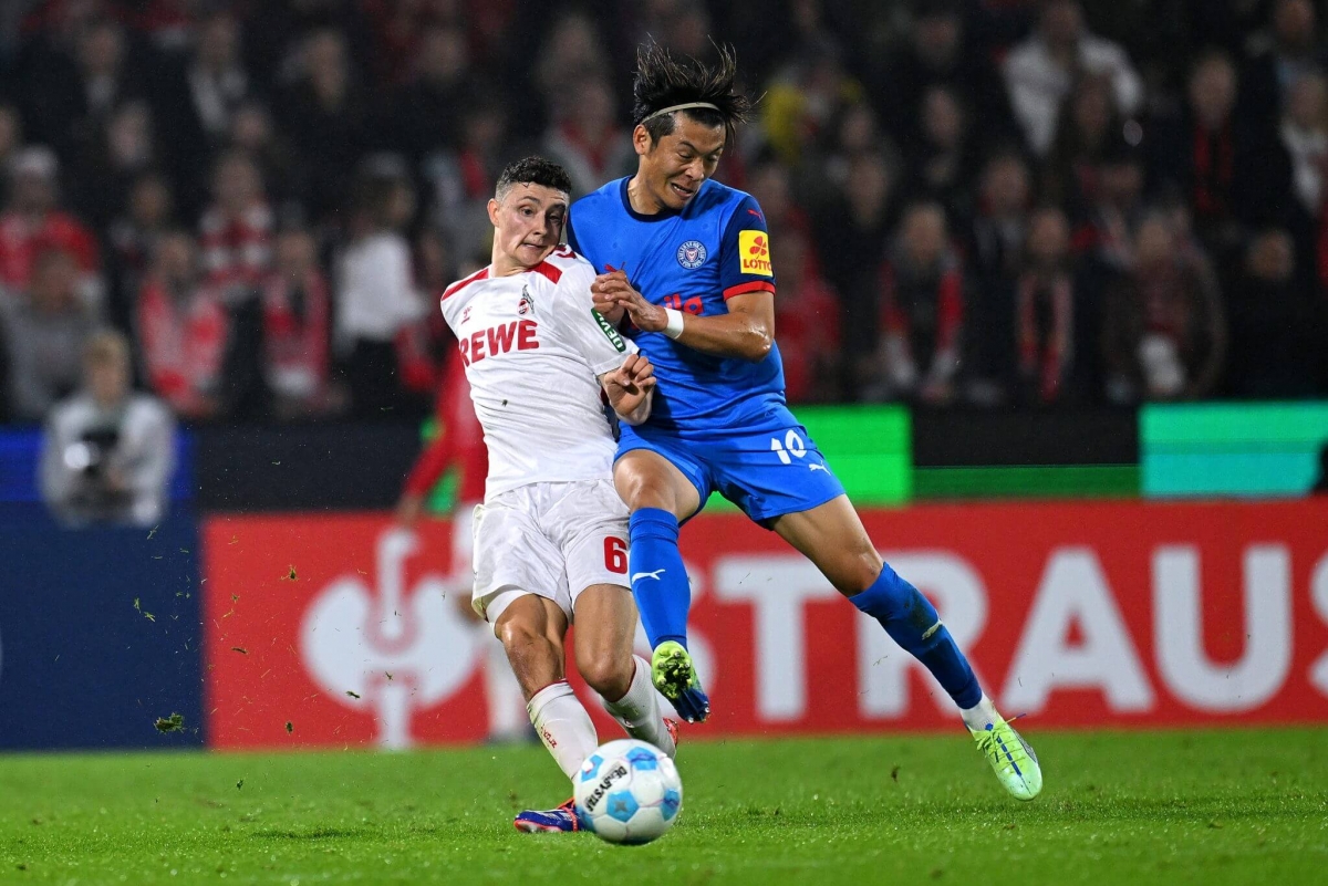 Shuto Machino (áo xanh) chơi cho Kiel tại Bundesliga.