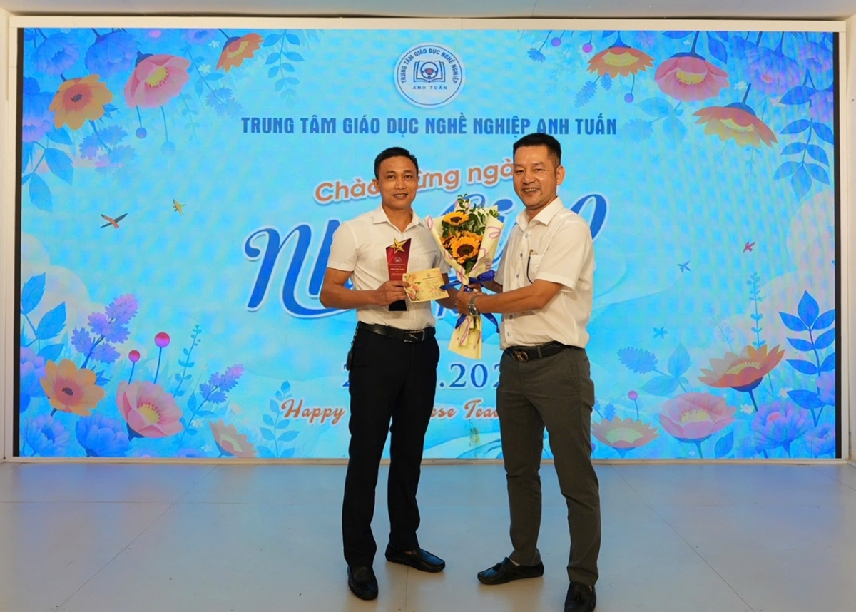 Thầy Phan Anh Tuấn, phó giám đốc trung tâm giáo dục nghề nghiệp Anh Tuấn (Người đứng bên phải) trao chứng chỉ tốt nghiệp nghề cho học viên.