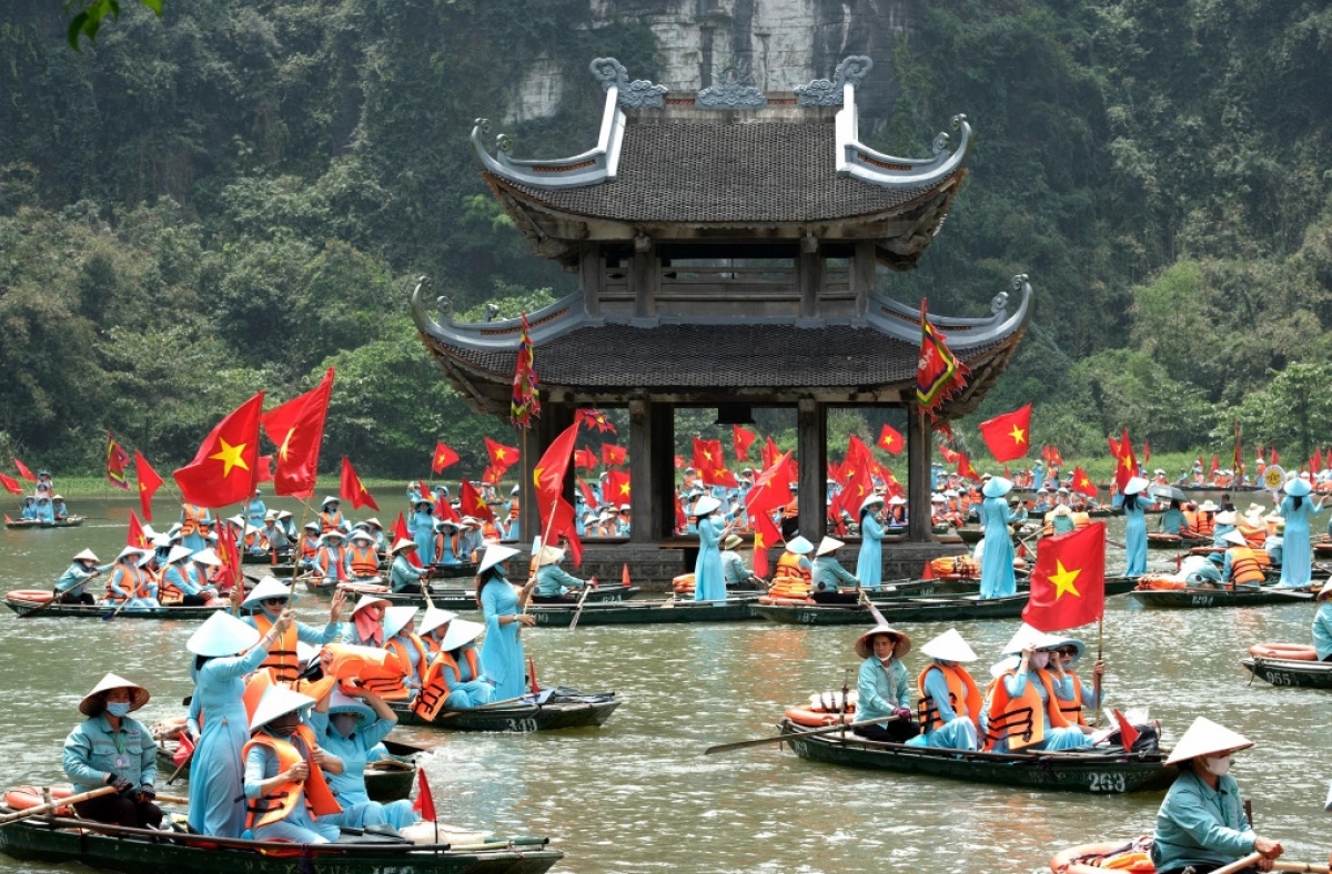 Hơn 1000 phụ nữ lập kỷ lục "Chương trình có số lượng phụ nữ cùng mặc áo dài xanh và đội nón lá tham gia đi thuyền trên sông đông nhất, với thông điệp ca ngợi hòa bình, bảo vệ di sản". Ảnh: Tràng An