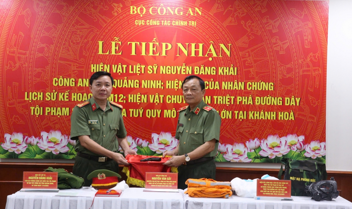 Thiếu tướng Đặng Ngọc Bách, Phó Cục trưởng Cục Công tác chính trị, Bộ Công an (phải) tiếp nhận hiện vật từ Công an tỉnh Kiên Giang. Ảnh: BTC