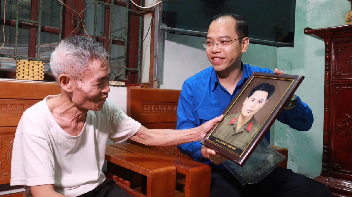 Phó Bí thư Thành đoàn Hà Nội Nguyễn Tiến Hưng trao tặng di ảnh phục dựng chân dung liệt sỹ cho thân nhân, gia đình liệt sỹ, gia đình có công với cách mạng trên địa bàn thành phố Hà Nội (Ảnh: Thành đoàn Hà Nội)