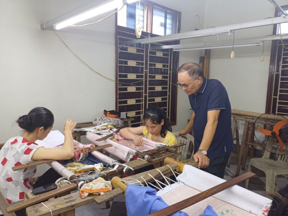 Nghệ nhân Hoàng Đình Chiêm, Giám đốc Công ty TNHH Thêu xuất khẩu Tuấn Dương
đang kiểm tra sản phẩm trong xưởng