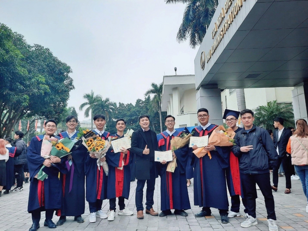 Hai sinh viên lớp K63AE chụp ảnh với các bạn và thầy hướng dẫn trong ngày tốt nghiệp (Ảnh nhà trường CC)