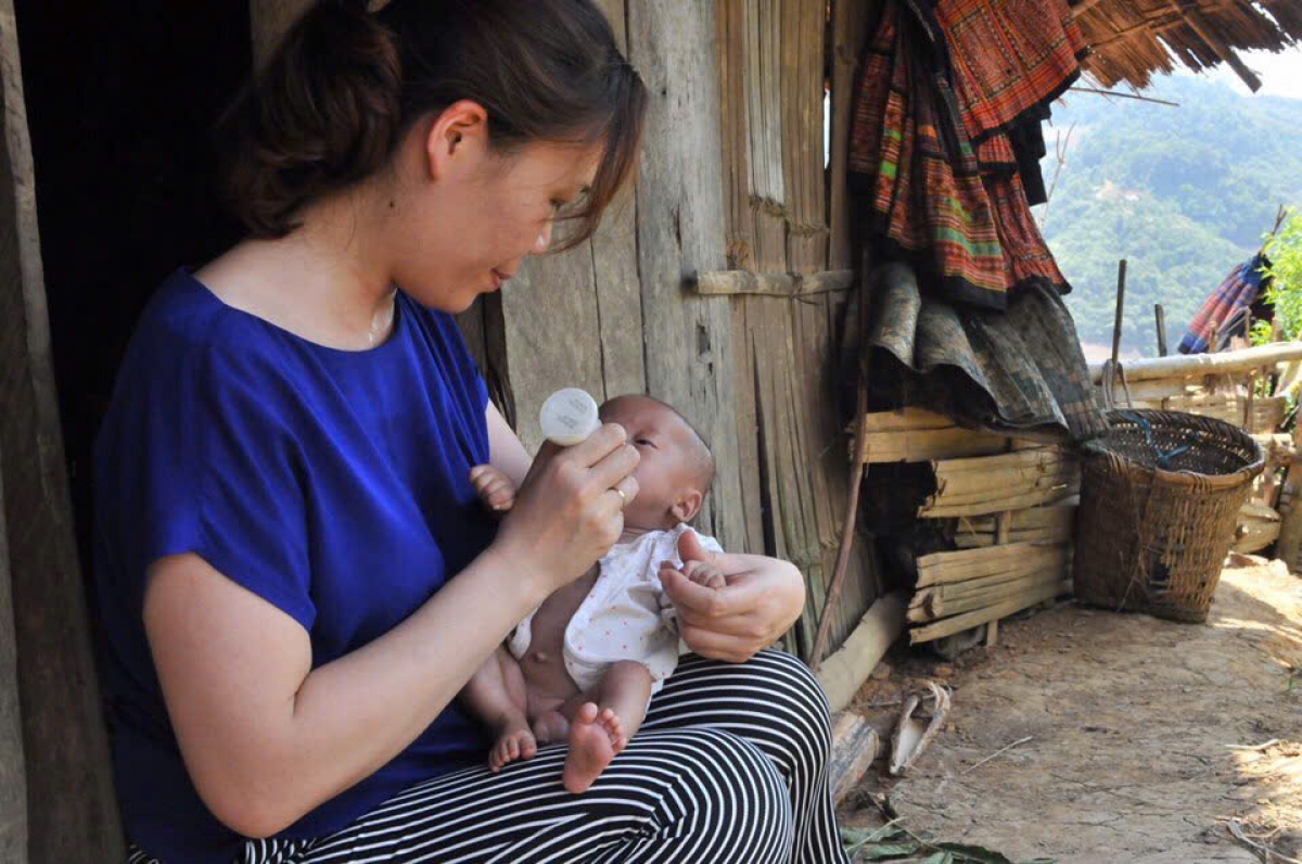 Nhà báo Thanh Tâm mang sữa lên cho bé Sồng A Tủa ở bản Pha Luông, Mộc Châu, Sơn La. Nhà báo Thanh Tâm cũng là người đặt tên cho bé. Ảnh: NVCC