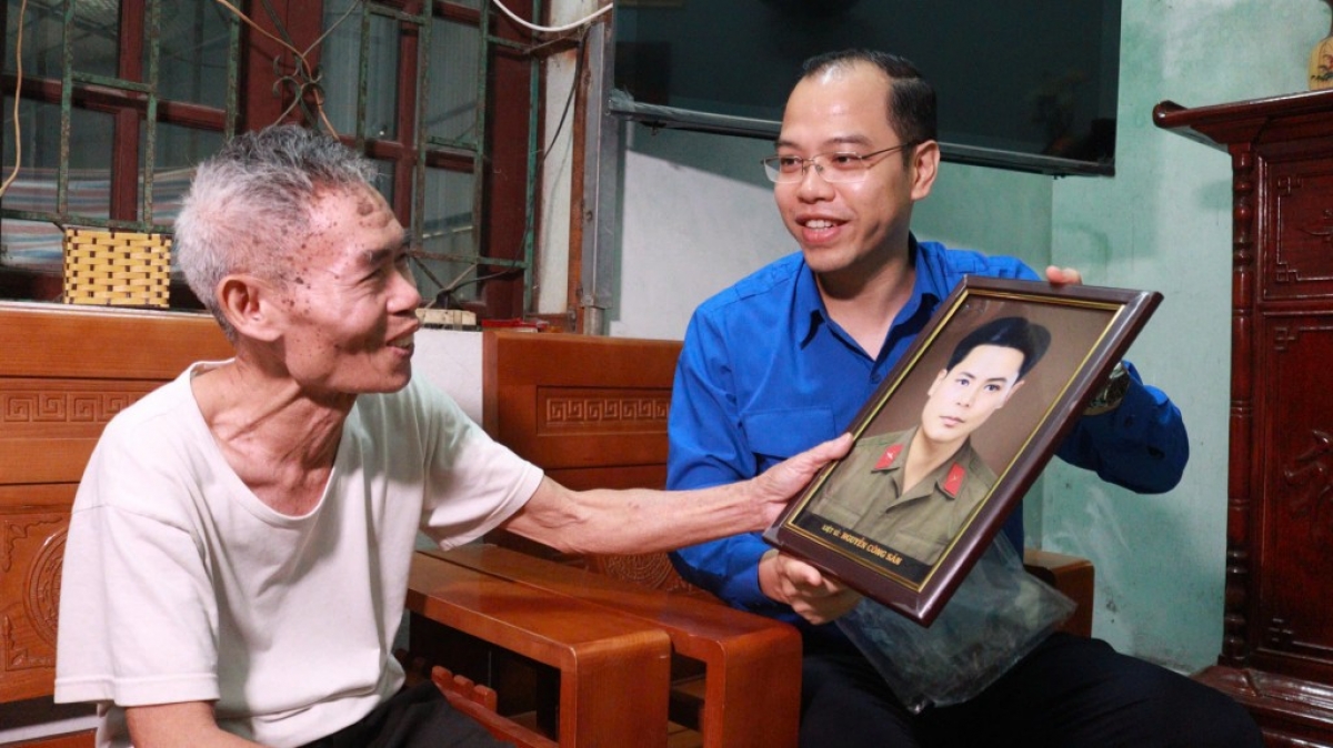 Phó Bí thư Thành đoàn Hà Nội Nguyễn Tiến Hưng trao tặng di ảnh phục dựng chân dung liệt sỹ cho thân nhân, gia đình liệt sỹ, gia đình có công với cách mạng trên địa bàn thành phố Hà Nội (Ảnh: Thành đoàn Hà Nội)