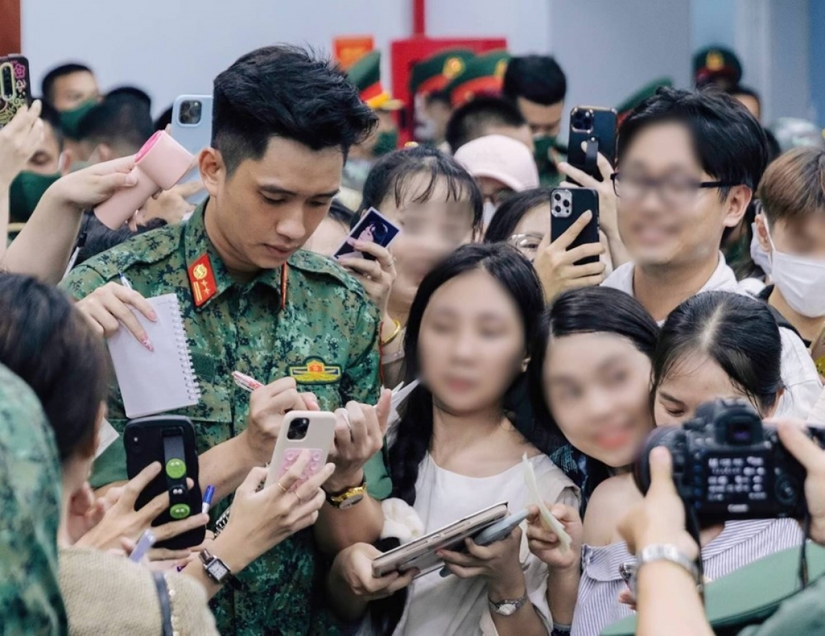 Thượng úy Lê Hoàng Hiệp bị "bao vây" xin chữ ký - Ảnh: Báo Thanh niên
