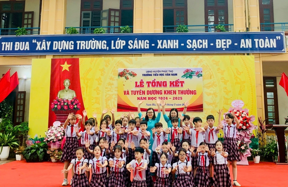 Cô giáo Nguyễn Thị Lan Anh, hiệu trưởng tiểu học Vân Nam, huyện Phúc Thọ, Hà Nội (Áo dài xanh bên trái ảnh) cùng các em học sinh của trường