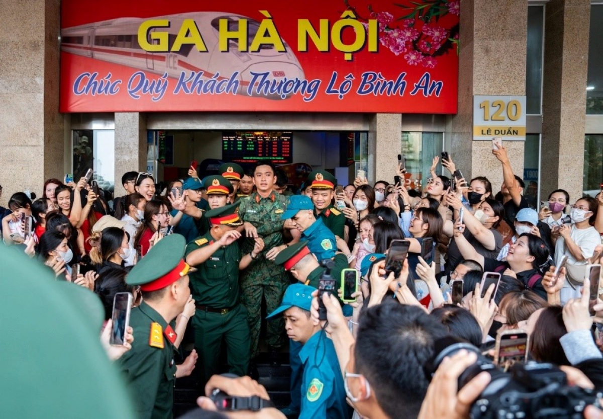 Thượng úy Lê Hoàng Hiệp vượt qua "rừng" người chào đón tại Ga Hà Nội - Ảnh: Báo Dân trí