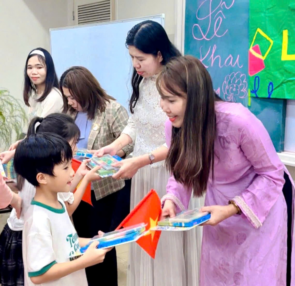 Bà Lê Thương (Áo tím) trao quà cho học sinh trong ngày khai giảng (Ảnh: NVCC)