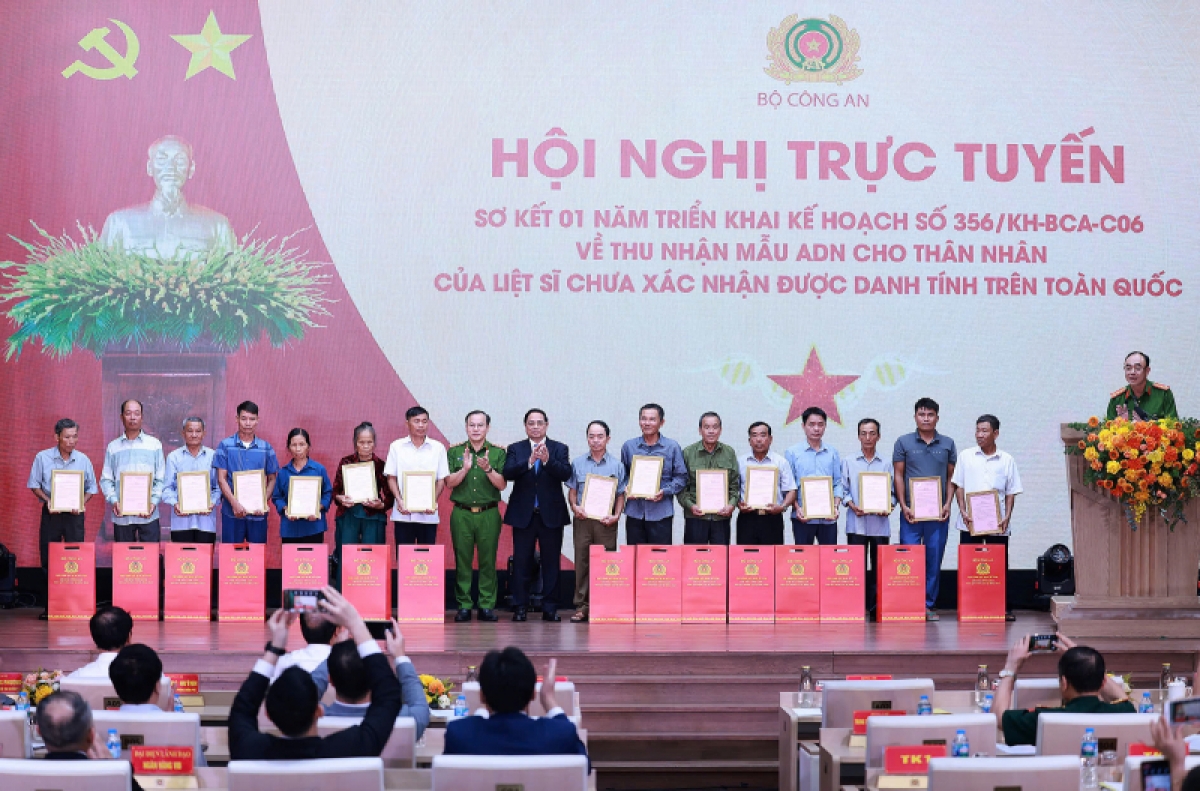 Thủ tướng Chính phủ và Thứ trưởng Bộ Công an trao kết quả xác định danh tính các liệt sĩ cho thân nhân gia đình các liệt sĩ. Ảnh (Bộ Công an)