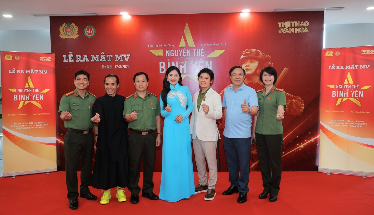 Nhạc sĩ Nguyễn Văn Chung và ca sĩ Duyên Quỳnh chụp ảnh cùng khách mời tại lễ ra mắt MV Nguyện thề vì bình yên. Ảnh: BTC