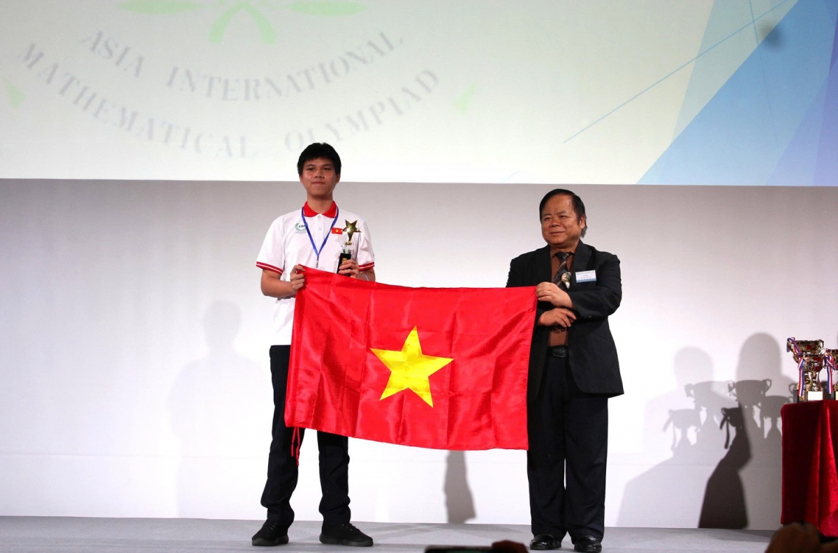 Quán quân AIMO 2025 Phan Thành Huy đại diện cho Việt Nam nhận cờ luân lưu đăng cai tổ chức AIMO 2026 (Ảnh: BTC)