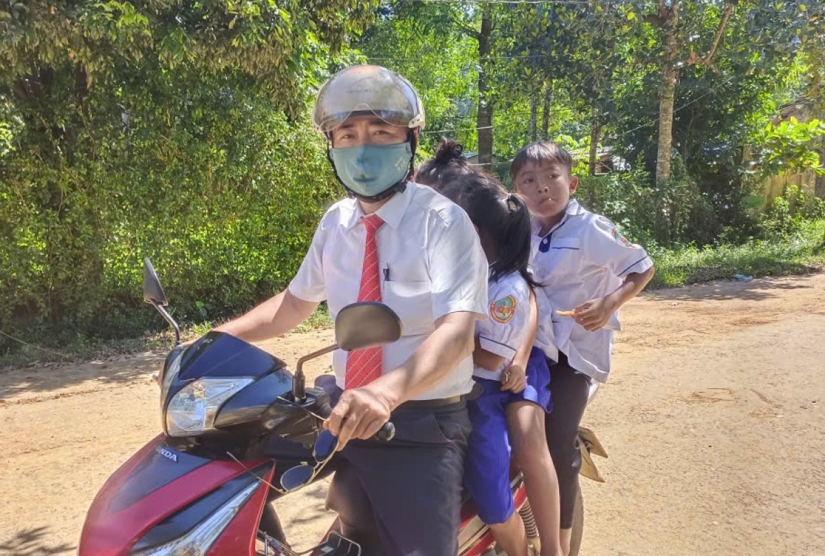 Thầy giáo chở học sinh đến điểm trường trung tâm tham dự lễ Khai giảng.