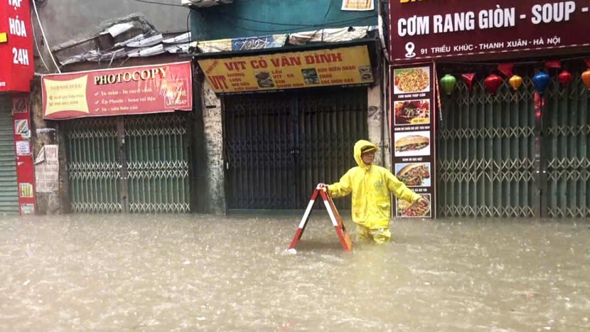 Nhân viên Công ty thoát nước Hà Nội cảnh báo khu vực ngập sâu (Ảnh: đơn vị cung cấp)