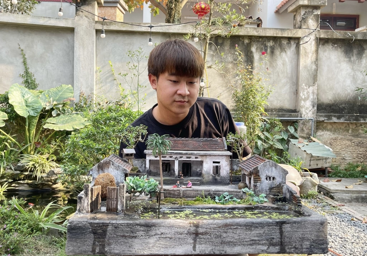 Nghệ nhân trẻ Trương Bộ bên mô hình tiểu cảnh nhà xưa (Ảnh NVCC)