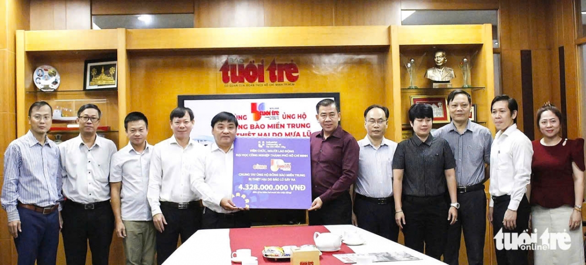 PGSTS Phan Hồng Hải, Hiệu trưởng Trường ĐHCN TPHCM (áo đỏ đứng giữa) và đại diện nhà trường trao tiền ủng hộ người dân vùng lũ lụt (Ảnh: Trần Huỳnh)