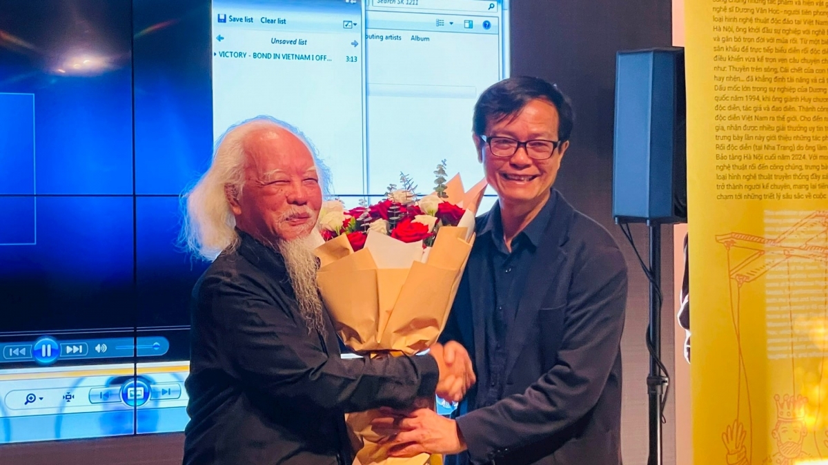 Ông Nguyễn Tiến Đà- Giám đốc Bảo tàng Hà Nội tặng hoa chúc mừng nghệ sĩ Dương Văn Học tại buổi khai mạc trưng bày. Ảnh: Bảo tàng Hà Nội