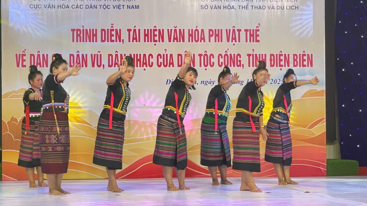 Nhóm nghệ nhân nữ dân tộc Cống trong trang phục váy thổ cẩm nhiều màu sắc đang thực hiện một động tác múa đồng bộ, thể hiện sự vui tươi và gắn kết cộng đồng. Chương trình nhằm mục đích bảo tồn và phát huy các giá trị văn hóa phi vật thể của dân tộc Cống. Nguồn: Ảnh do đơn vị tổ chức cung cấp.