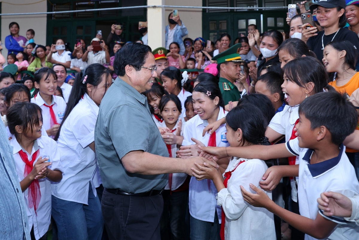 Thủ tướng Phạm Minh Chính và các em học sinh xã miền núi. Ảnh: VGP