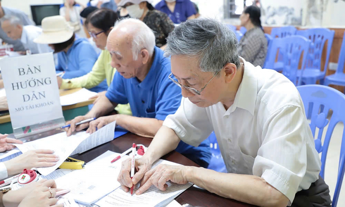 Người hưởng lương hưu làm thủ tục nhận lương hưu qua tài khoản. Ảnh: BHXH Việt Nam cung cấp
