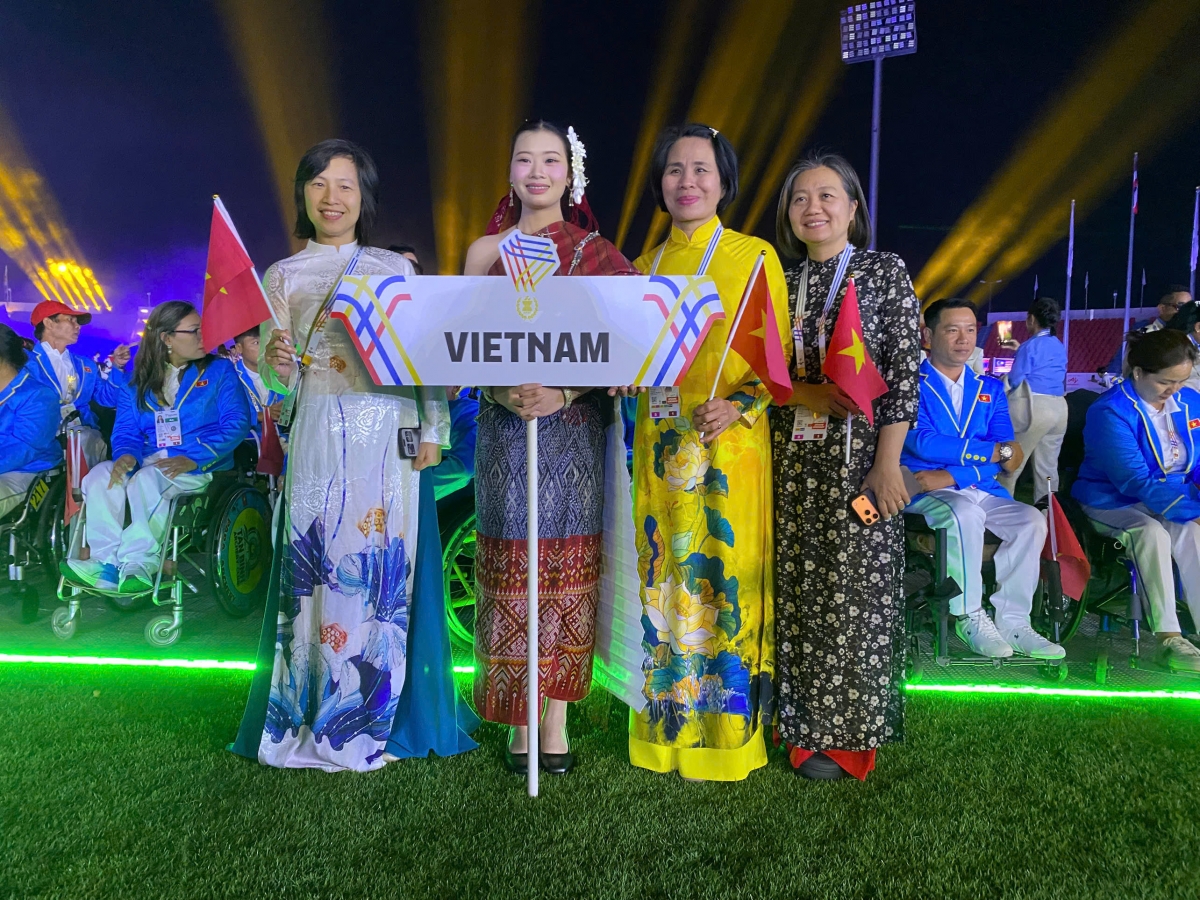 Trưởng đoàn thể thao NKT Việt Nam, Lê Thị Hoàng Yến (áo dài vàng), chụp ảnh kỷ niệm cùng các VĐV trong buổi lể khai mạc Para Games 13. Ảnh: VIETNAM PARASPORT. 