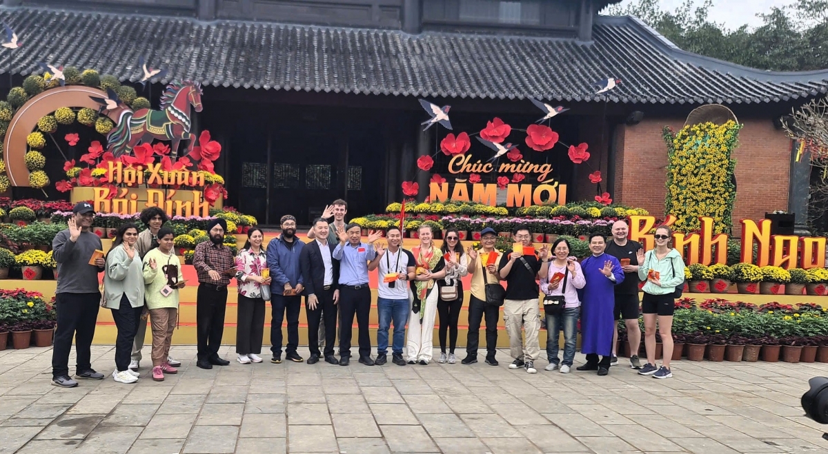 Lãnh đạo Sở Du lịch Ninh Bình tặng hoa và lì xì cho những vị khách đầu tiên "xông đất". Ảnh: Sở Du lịch Ninh Bình