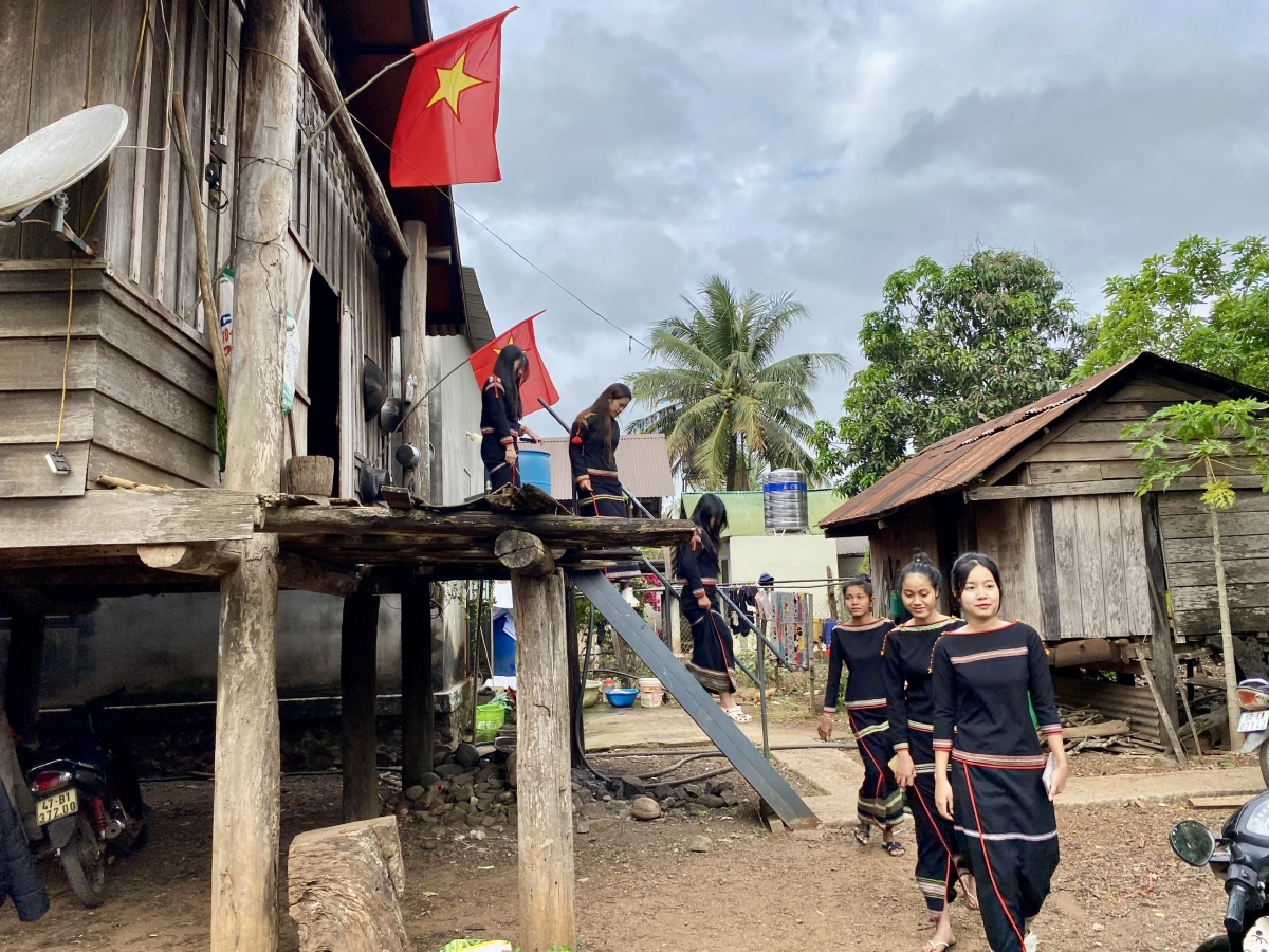 Những cô gái Ê Đê bước xuống nhà dài để chuẩn bị đi bỏ phiếu bầu cử và hỗ trợ công tác bầu cử