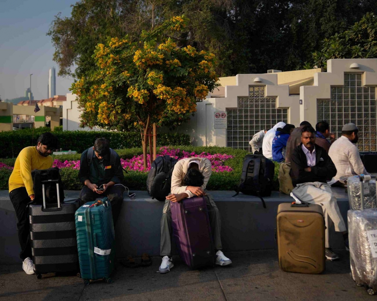 Hành khách bị mắc kẹt do sân bay Dubai đóng cửa đang chờ được hỗ trợ tại bãi đỗ xe. Ảnh: Altaf Qadri/AP
