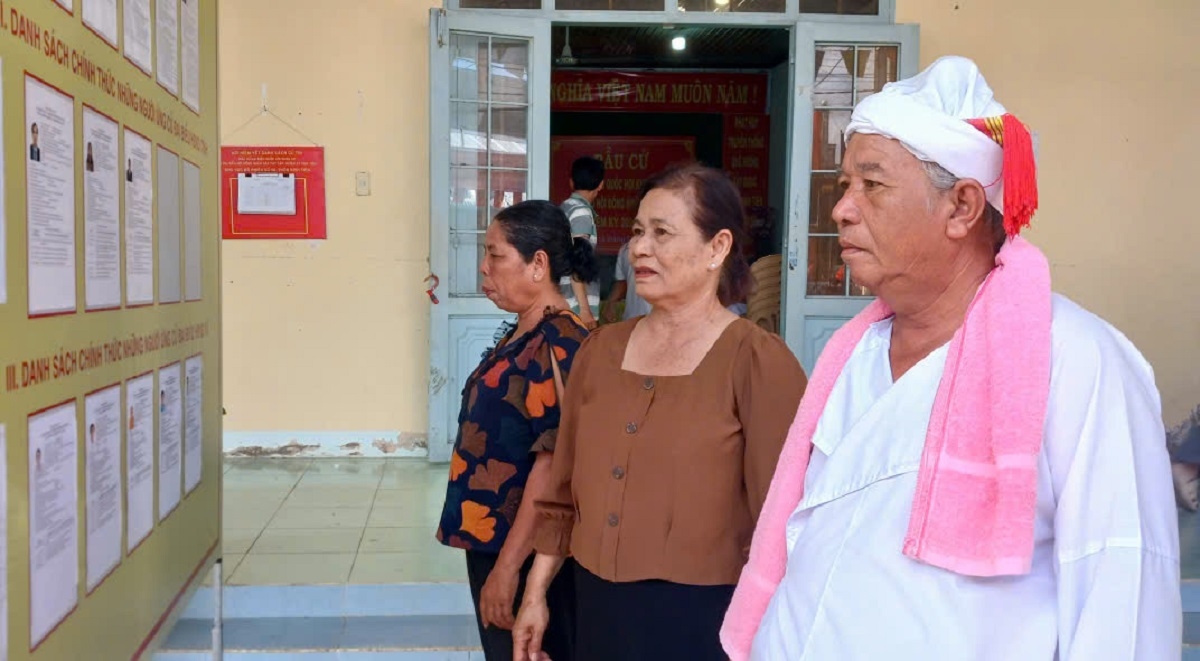 Sư cả Huỳnh Cứng- một chức sắc người Chăm ở thôn Bình Tiến, xã Bắc Bình đang xem tiểu sử của các ứng cử viên (Ảnh: Đoàn Sỹ)