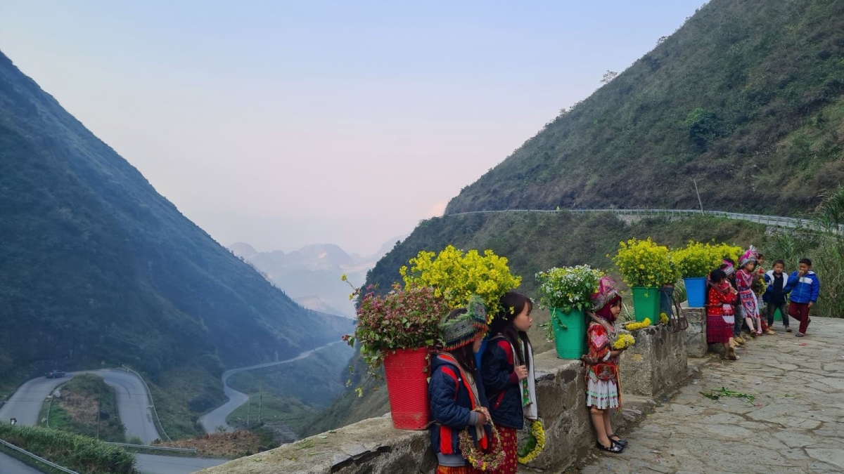 Các em nhỏ gùi trên lưng đủ các loại hoa và luôn sẵn sàng chụp ảnh cùng du khách. Nguồn: moitruongxaydung.vn