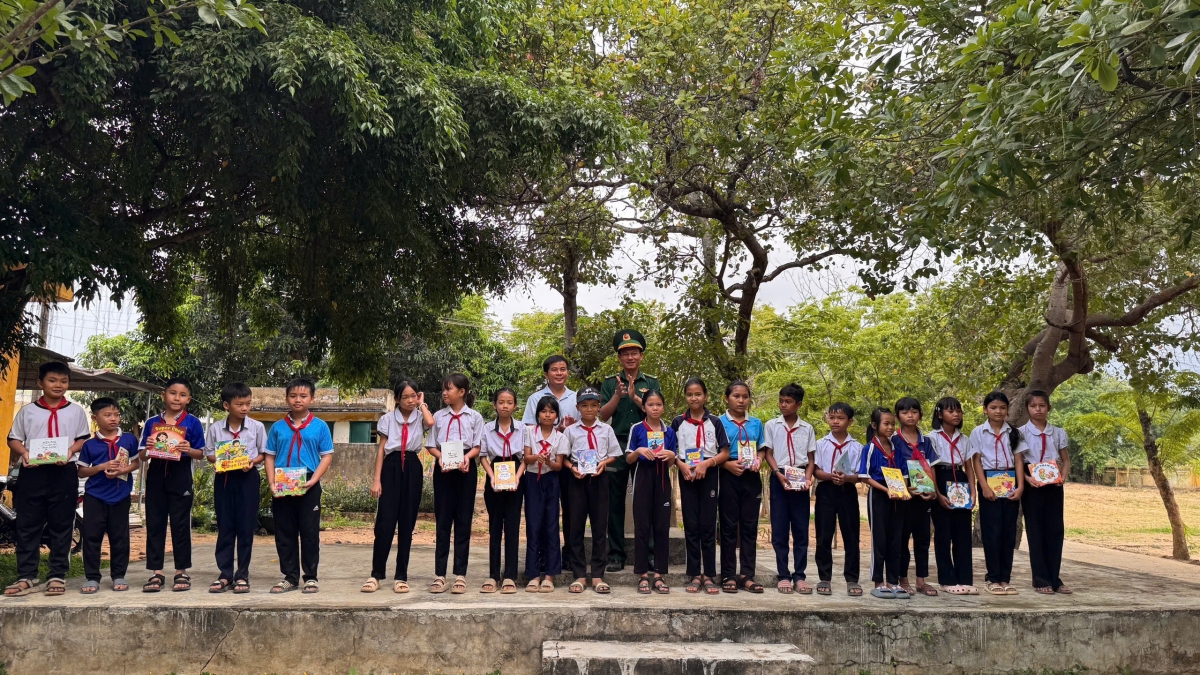 Đại diện đồn biên phòng trao tặng những cuốn vở cho học sinh (Ảnh: CTV)