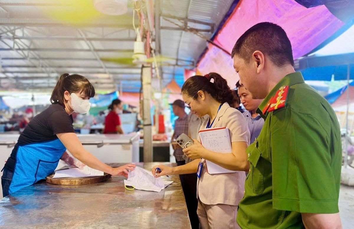 Đoàn kiểm tra liên ngành kiểm tra an toàn thực phẩm tại chợ dân sinh. Ảnh: Phương Xuyến- HNM