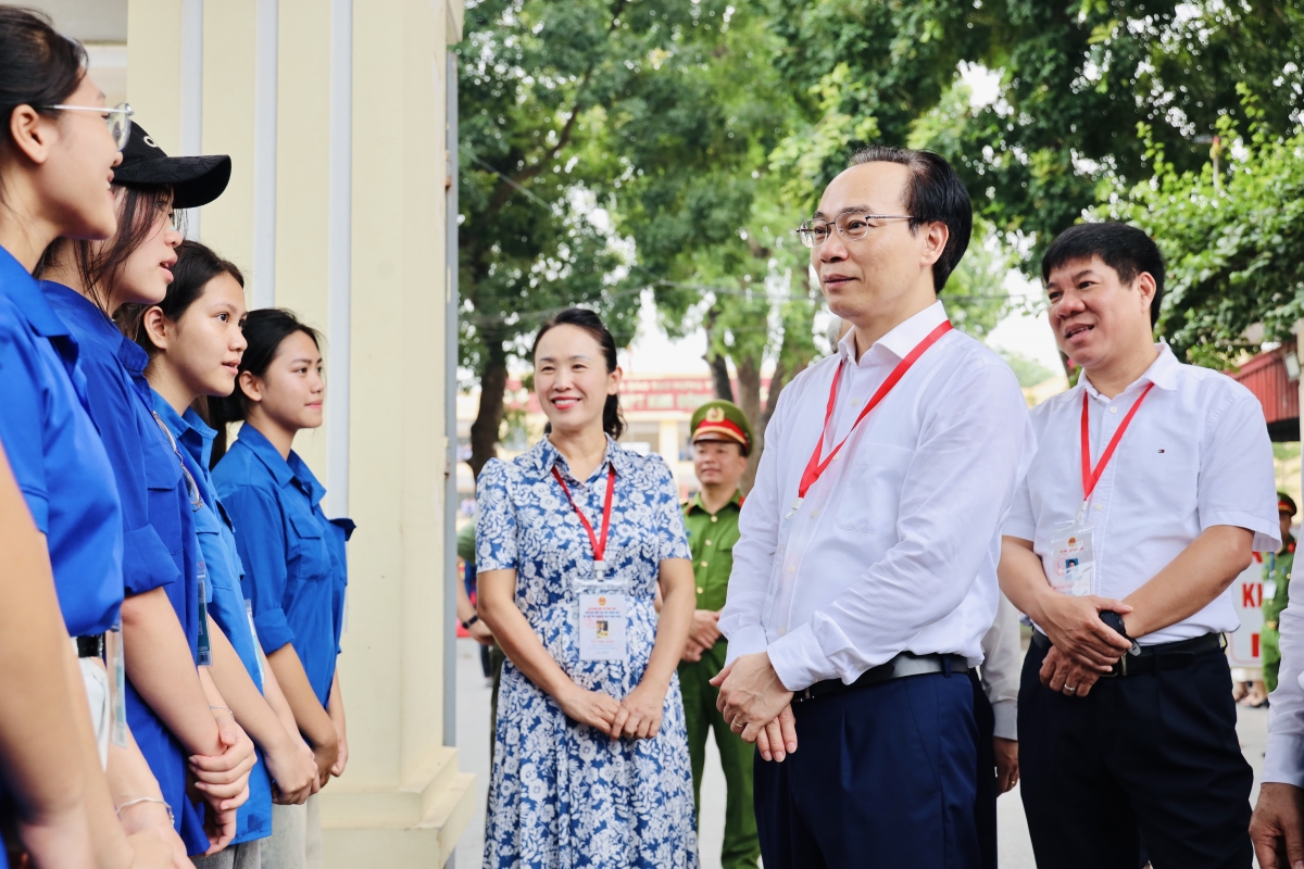 Bộ trưởng Hoàng Minh Sơn hỏi thăm lực lượng phục vụ kỳ thi tại điểm thi Trường THPT Kim Động (Hưng Yên) sáng 11/6. Ảnh: Nguyễn Mạnh