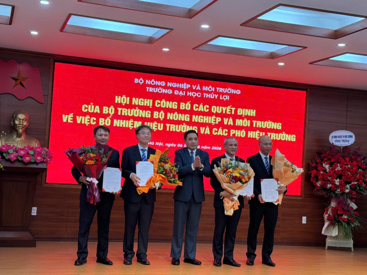Thứ trưởng Nguyễn Quốc Trị trao quyết định và tặng hoa chúc mừng các thành viên BGH trường ĐH Thủy Lợi (Ảnh: Thu Lương)