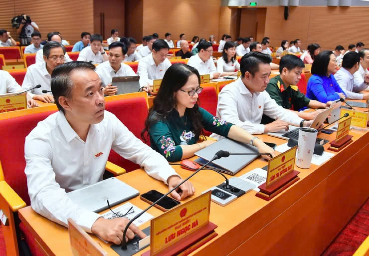 Đại biểu HĐND thành phố Hà Nội nhấn bút thông qua Nghị quyết (Ảnh KT)
