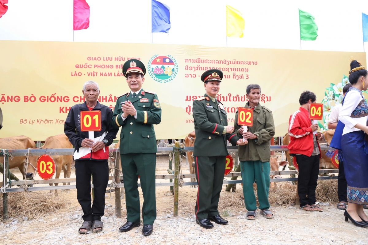 Bộ trưởng Bộ Quốc phòng 2 nước trao bò cho người dân Lào (Ảnh: Khánh Toàn)