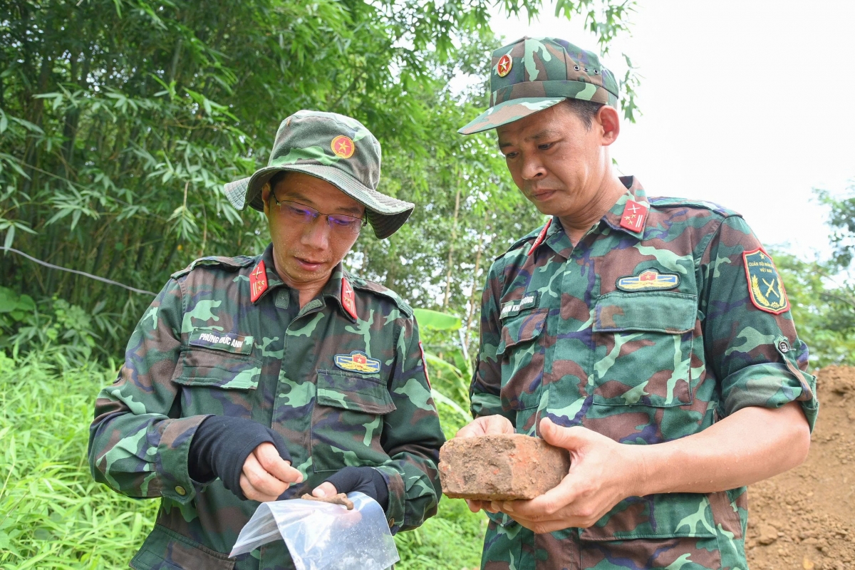 Thượng tá Phạm Khắc Trường (bên phải) cùng đồng nghiệp kiểm tra kỹ lưỡng từng di vật được tìm thấy trong quá trình khai quật - Ảnh: Hoàng Trung (Báo Quân khu 2)