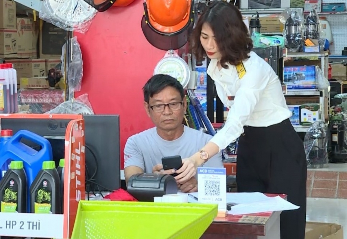 Công chức thuế cầm tay chỉ việc hỗ trợ hộ kinh doanh sử dụng eTax - Ảnh: Thuế tỉnh Thanh Hóa.