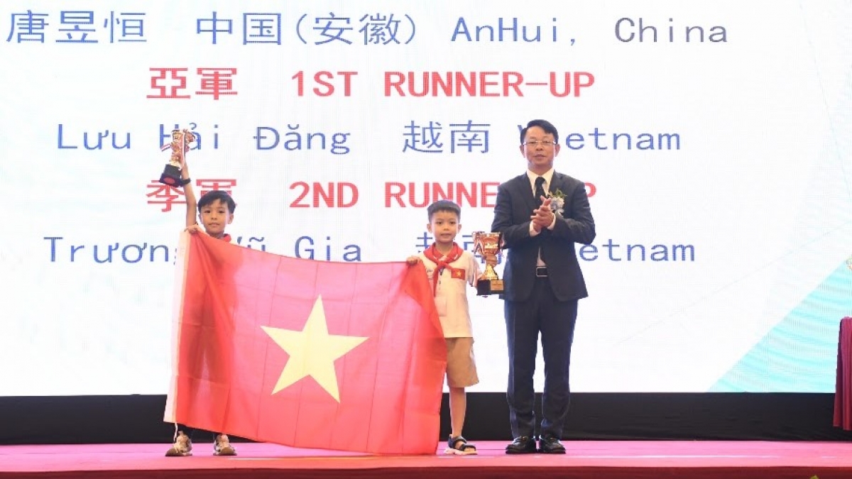Nhà báo Phùng Công Sưởng, Trưởng Ban tổ chức AIMO Việt Nam trao Huy chương Vàng cho thí sinh Việt Nam. (Ảnh: BTC)