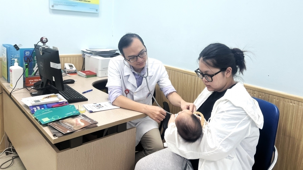 BS Nguyễn Văn Thành kiểm tra sức khỏe của trẻ trước khi tiêm phòng. Ảnh: BSCC